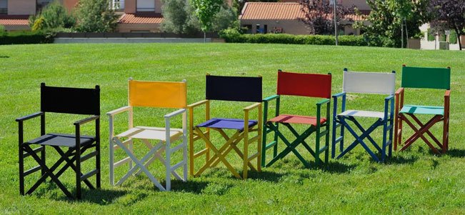 Sillones director Aranaz de madera en colores negro, amarillo y azul sobre el césped