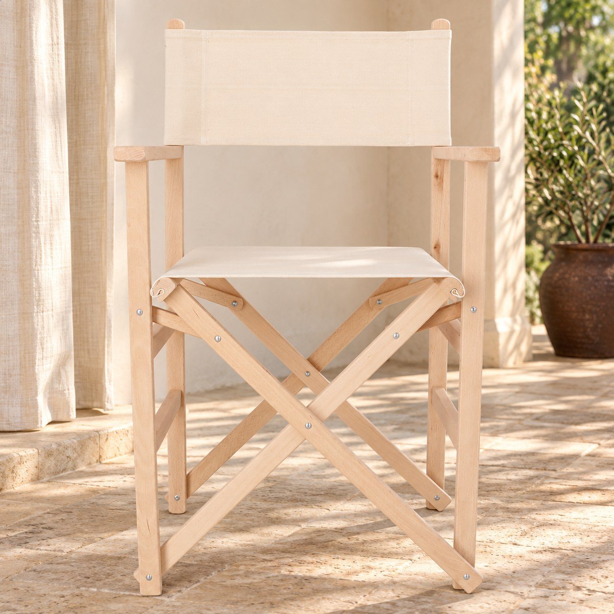 Sillón Director de madera natural y lona cruda en una terraza cubierta
